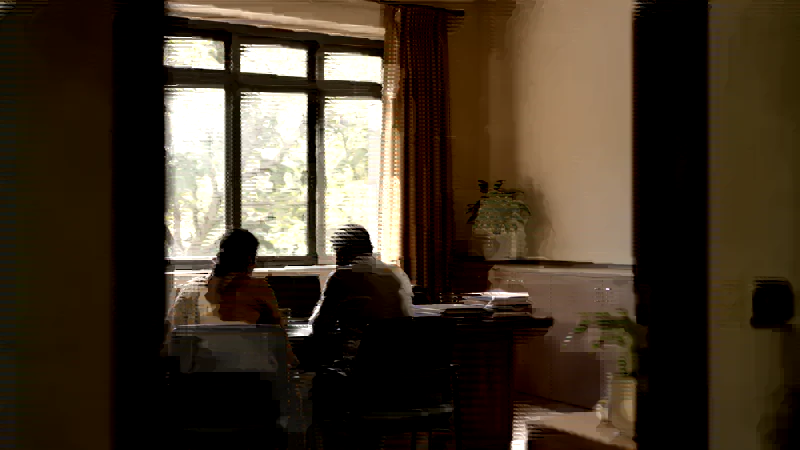 Two people in a school office reviewing a laptop together during a working session.